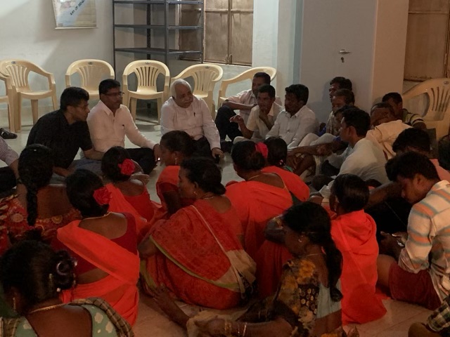 Founder in a floor-seated discussion with women farmers and village representatives